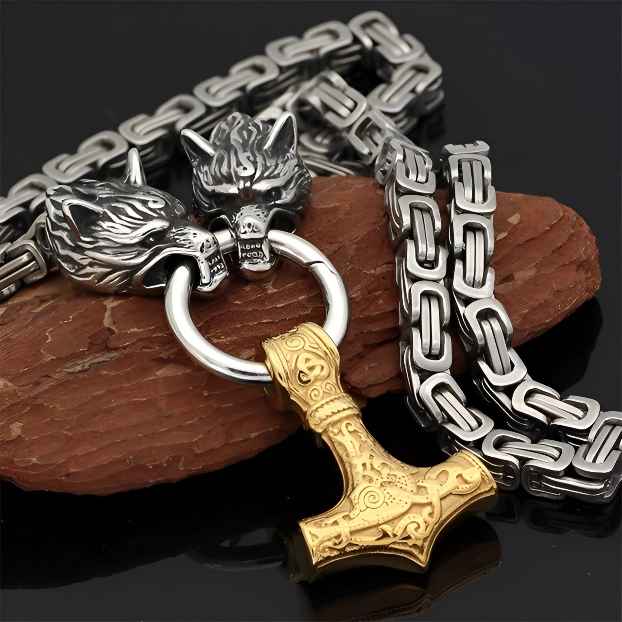 Silver Viking wolf head and Mjolnir pendant featuring a gold hammer design, displayed on a 90 cm silver chain, placed on a wooden surface.
