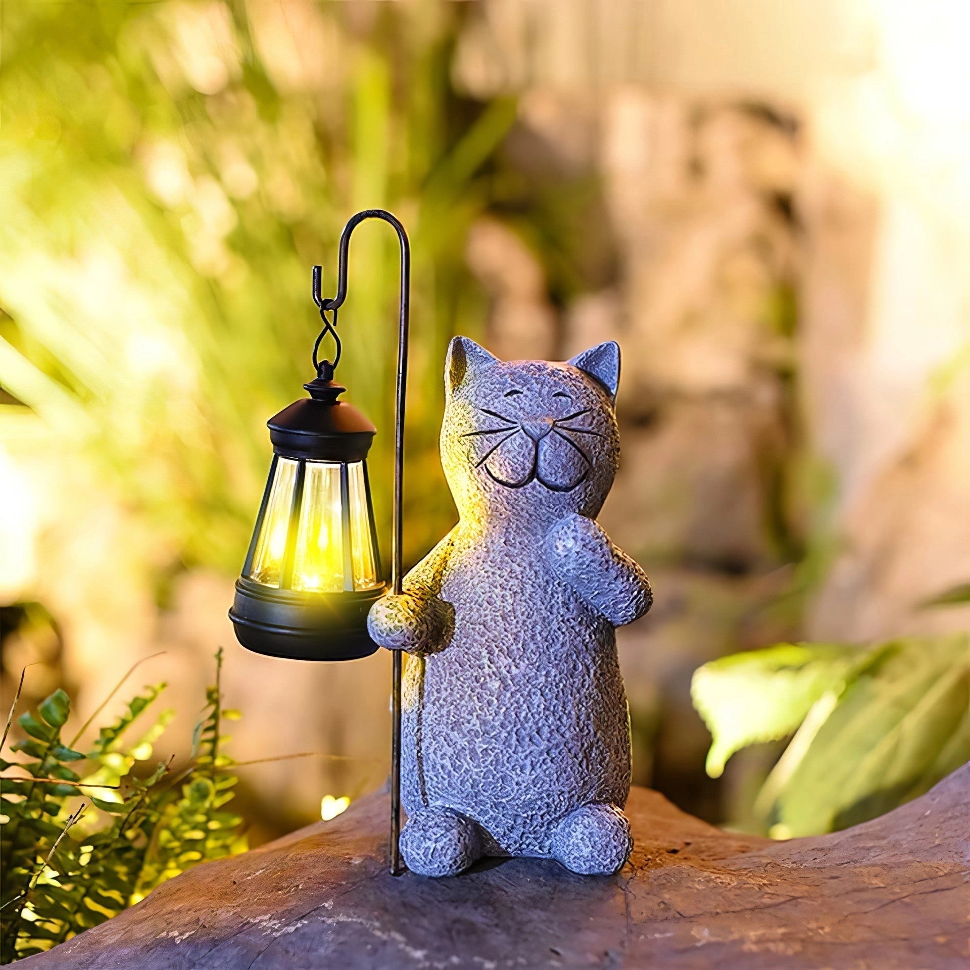 Whimsical solar cat lantern with a purple finish, designed as an eco-friendly outdoor garden decor piece, sitting on a wooden surface surrounded by grass and plants.