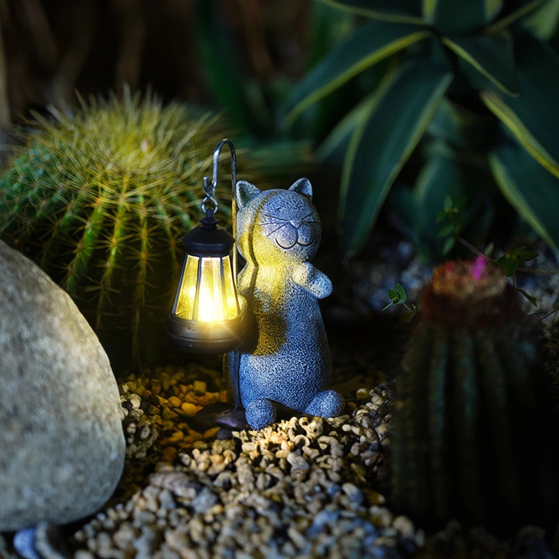 Whimsical solar-powered cat-shaped lantern nestled among plants and greenery in a garden setting, providing eco-friendly outdoor lighting.