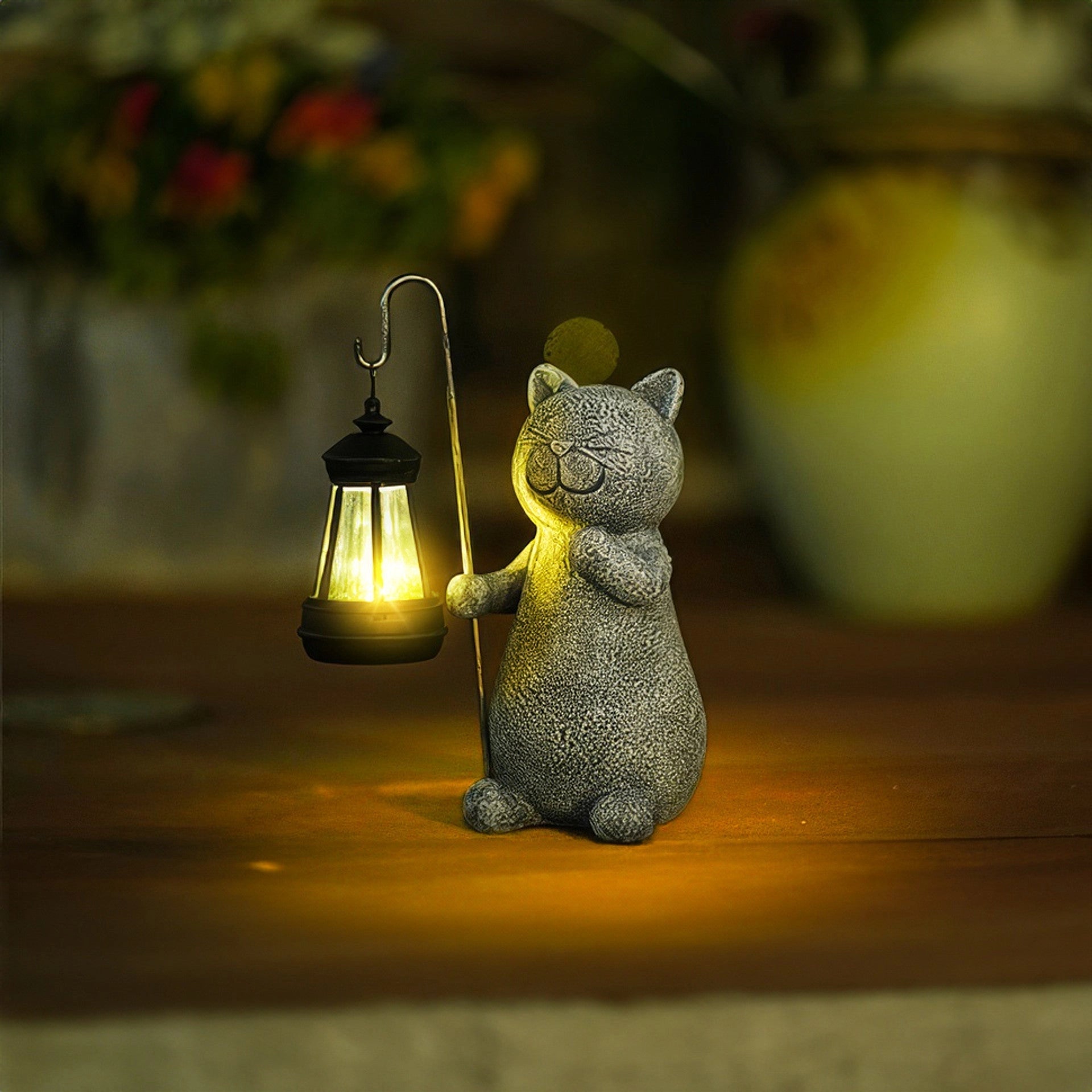 A whimsical solar-powered cat lantern made of metal and wood, featuring intricate whiskers and a fawn-like design, placed on grass outdoors.