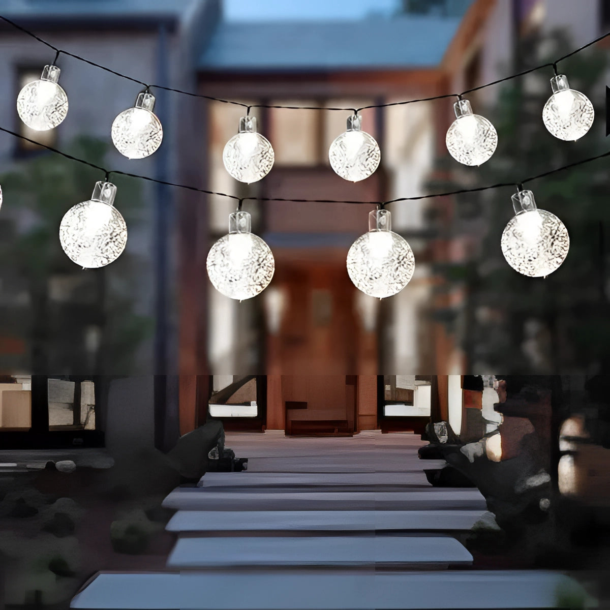 Solar crackled glass globe lights with LED bulbs hanging outdoors, showcasing a waterproof design suitable for garden or patio decoration. The lights emit a warm white glow, enhancing the ambiance of the space.