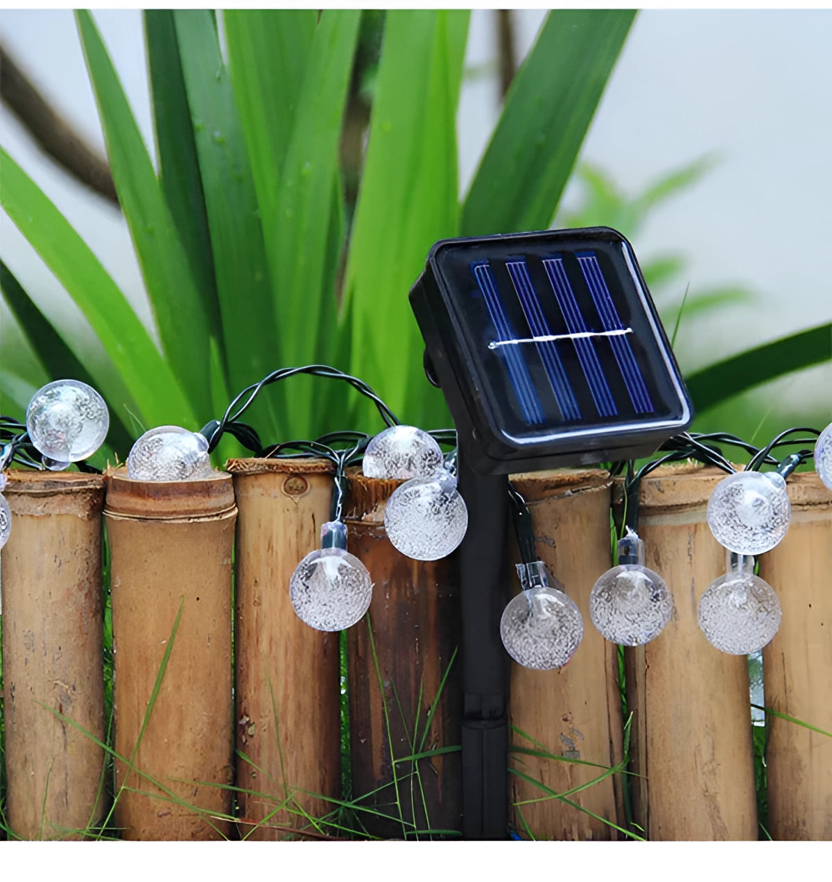 Solar crackled glass globe lights hanging amongst green grass and plants, featuring waterproof LED strings, with metal and wood elements visible in the outdoor setting.