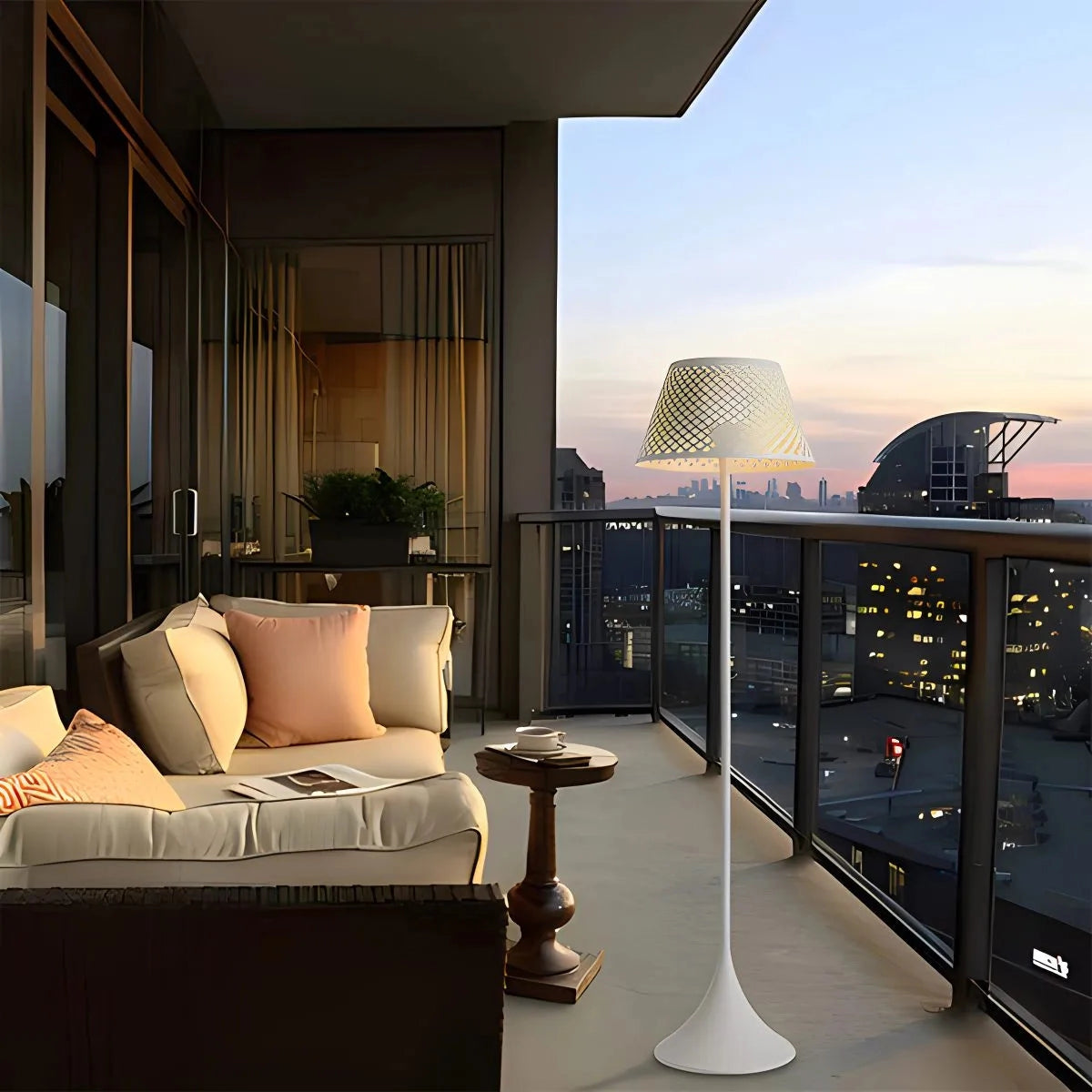 Tall floor lamp with mesh shade in sleek black industrial design, standing in a modern living room setting with a couch and other furnishings.