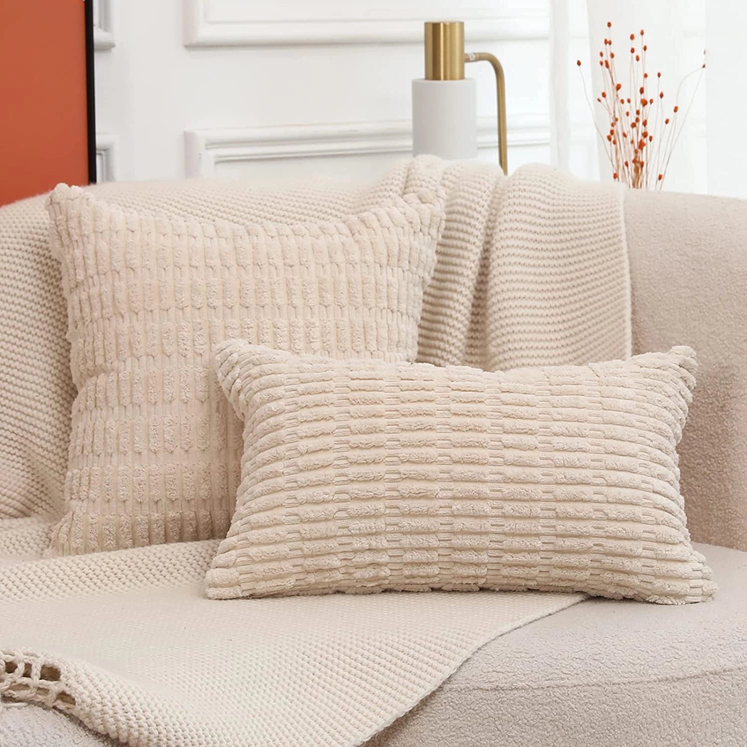 Beige textured corduroy cushions and lumbar pillows on a studio couch, enhancing the comfort and interior design of the living space.