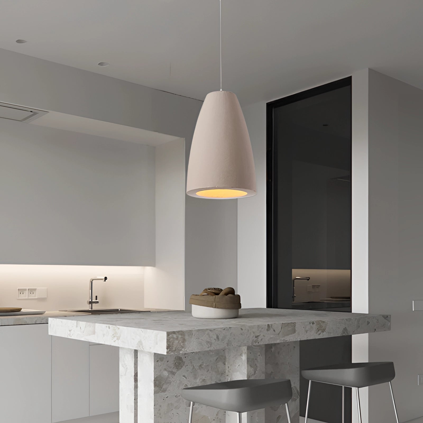 Textured oversized pendant light hanging above a minimalistic dining area with wooden furniture and grey interior design elements.