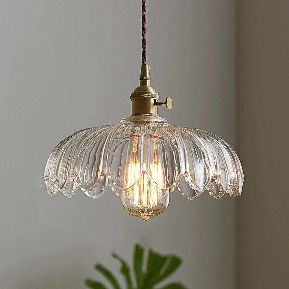 Vintage amber glass pendant light with a brass flower petal design, featuring a clear chandelier adorned with decorative elements, including an ornate light bulb, suitable for enhancing interior designs and adding elegance to any ceiling.