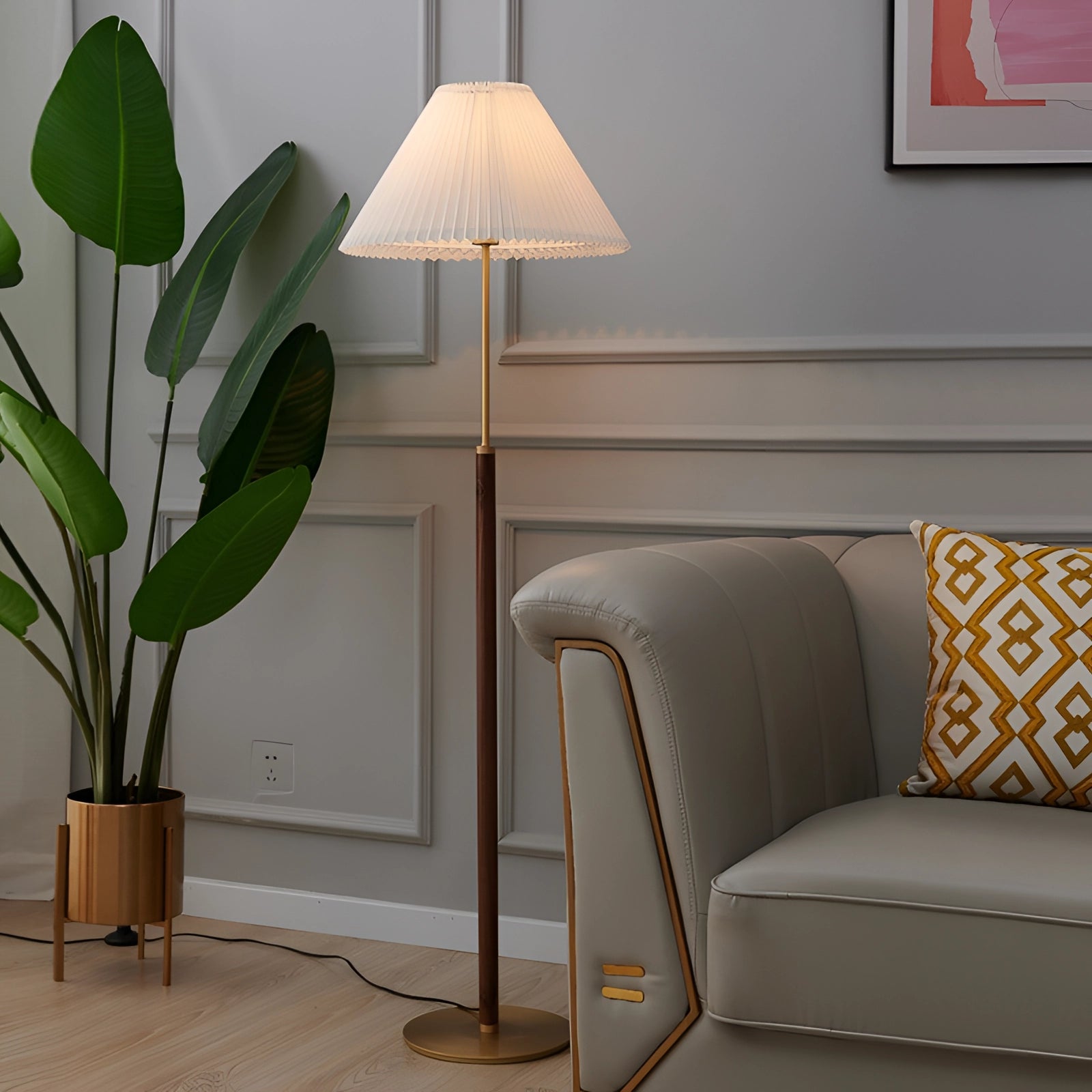 Vintage brass floor lamp with adjustable height and pleated shade, mid-century modern design, placed in a comfortable interior setting with wooden flooring and a plant nearby.