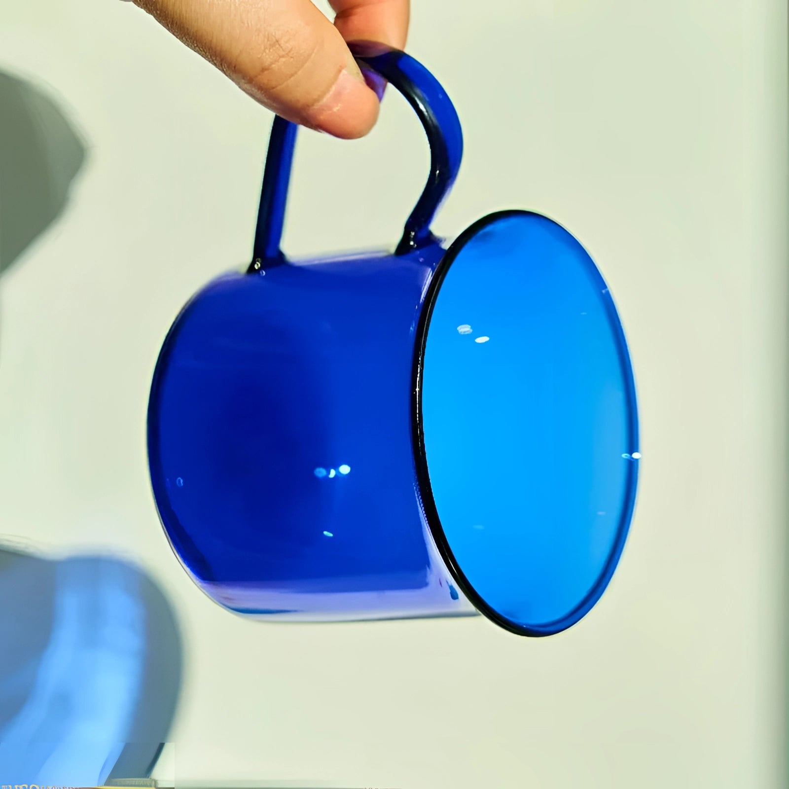 Vintage cobalt blue enamel mug set placed outdoors, showcasing durable drinkware with a rich azure hue.