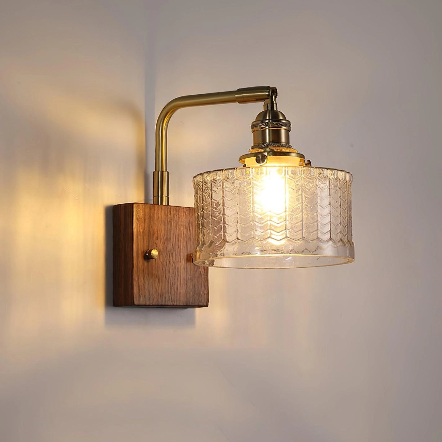 Vintage green glass sconce with a brass arm and fish scale pattern, featuring an amber hue and rectangular design.
