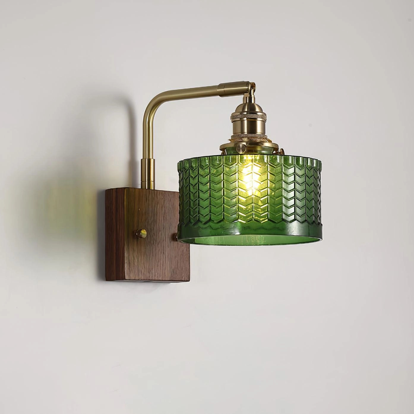 Vintage green glass sconce with a brass arm featuring a fish scale pattern.