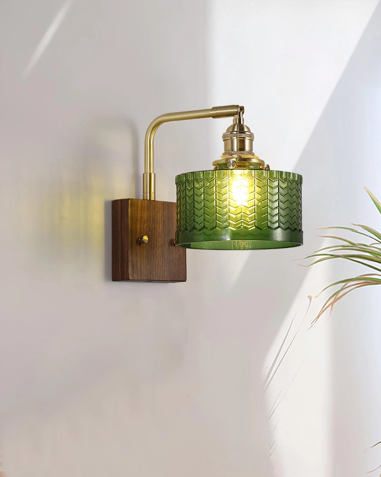 Vintage green glass sconce with a brass arm featuring a fish scale pattern, designed in a rectangular shape, adorned with ornamental details.