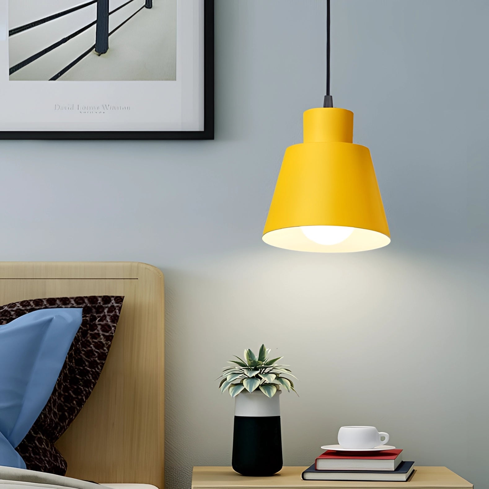 Yellow pendant light with a modern Scandinavian design, hanging in a cozy interior setting, featuring wooden accents and a white background.