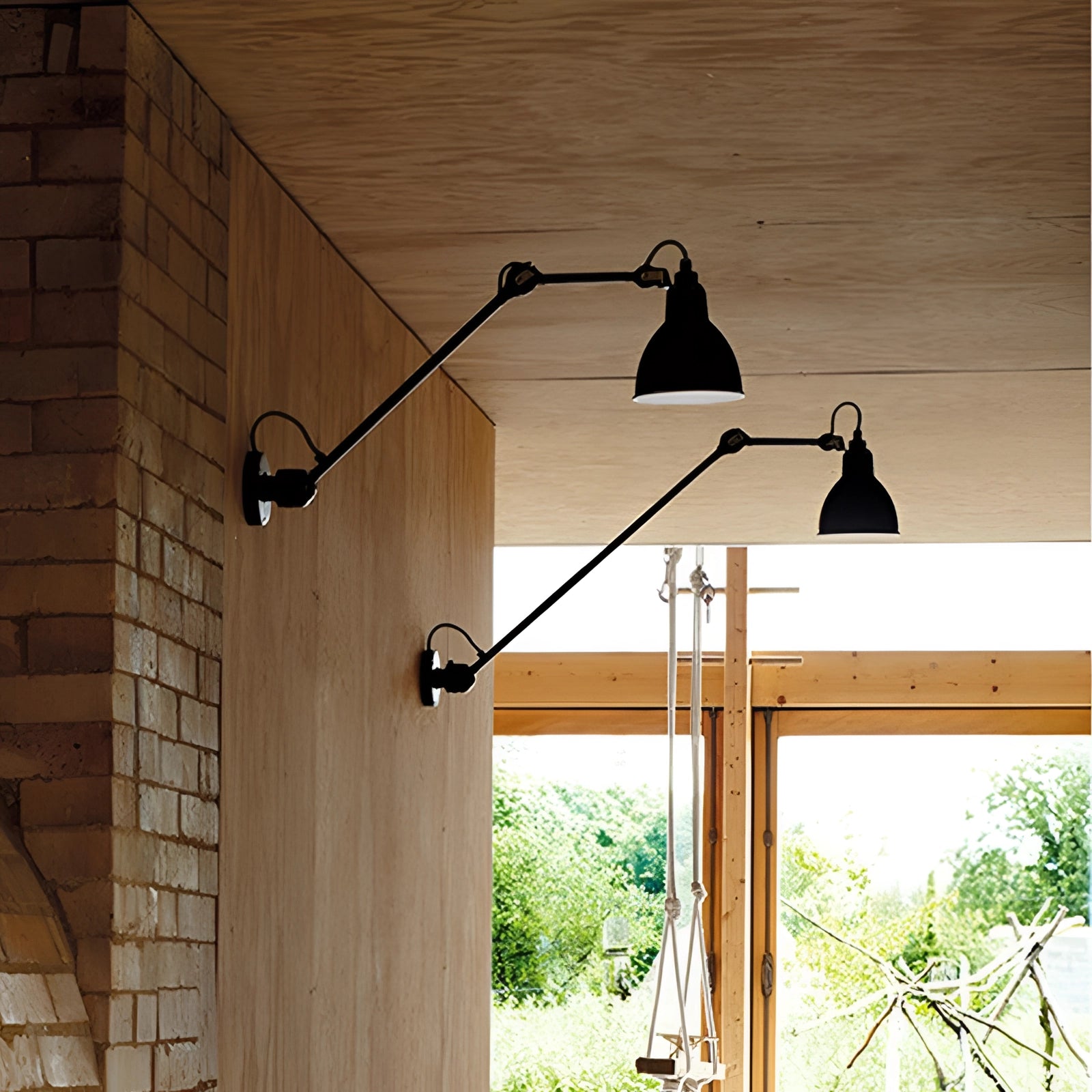 Adjustable black metal wall lamp in industrial style with LED sconce, mounted on a wooden wall, featuring a sleek black shade.