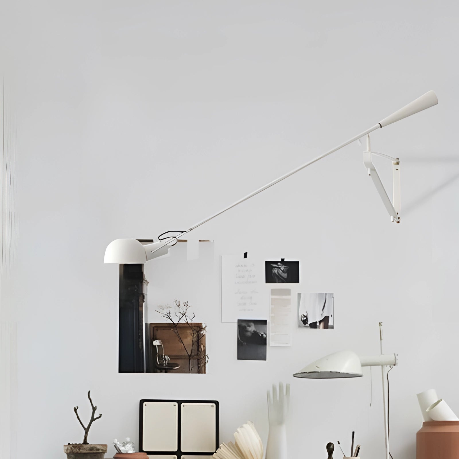 
A white adjustable industrial swing arm wall lamp with a sleek modern design mounted on a wall, enhancing the interior decor with its minimalist aesthetic.