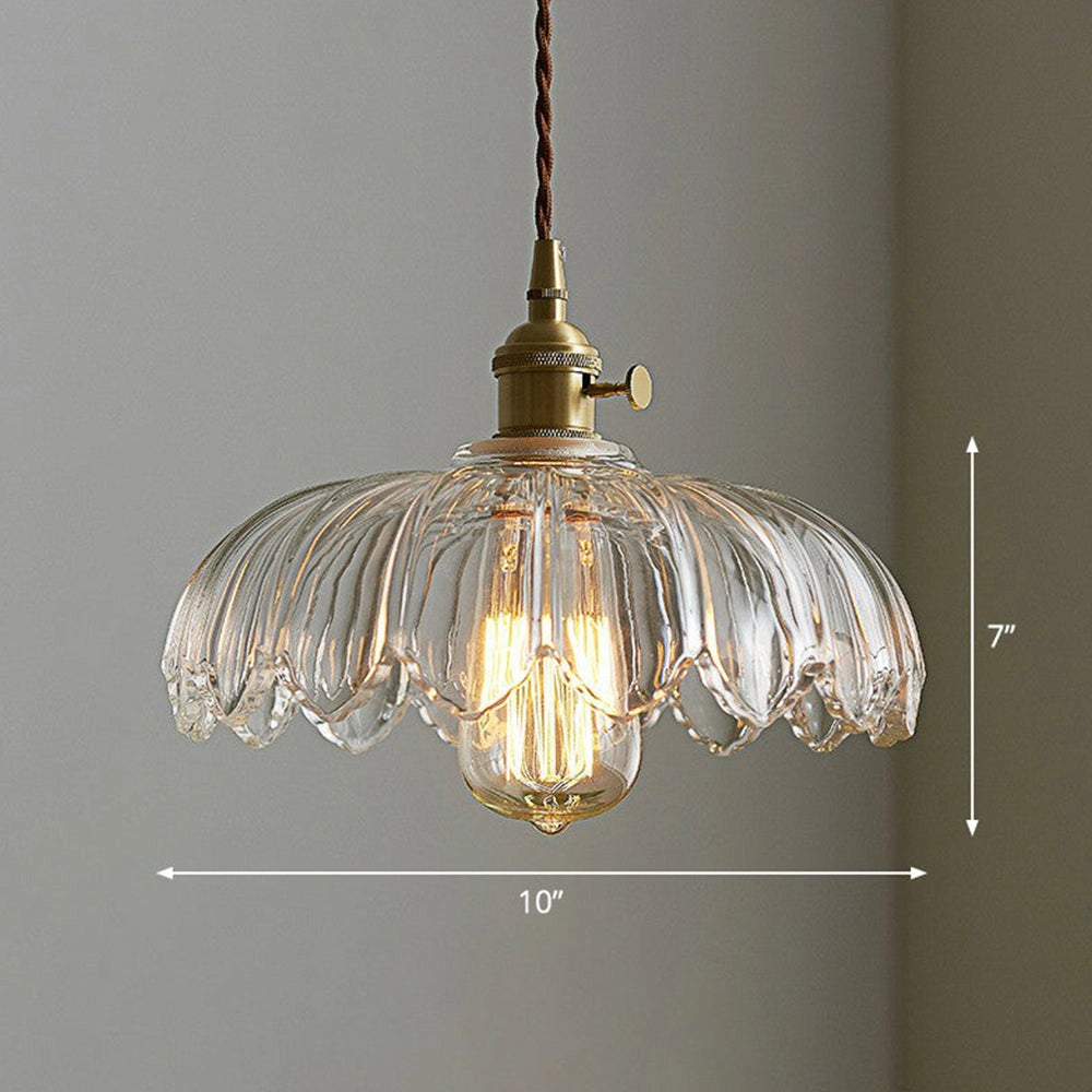 Amber glass floral pendant light with vintage brass chandelier design, featuring a metal fixture, illuminated by a light bulb, hanging from the ceiling.