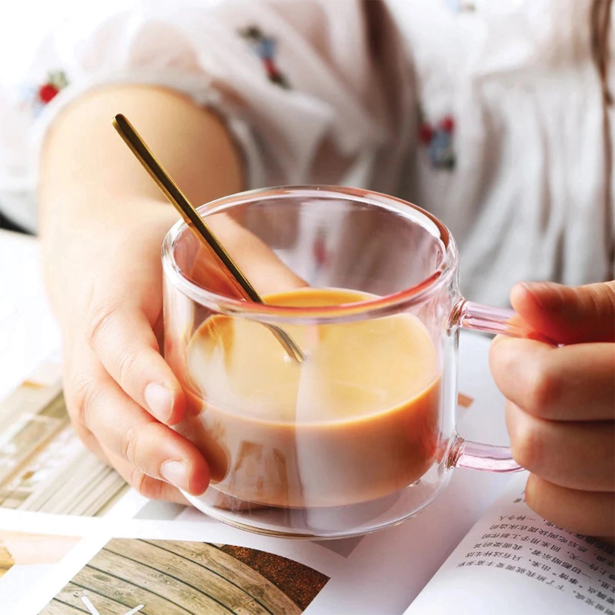 Amber glass mug being held by a hand, suitable for serving hot beverages like coffee or tea, featured as part of tableware and kitchen utensils.