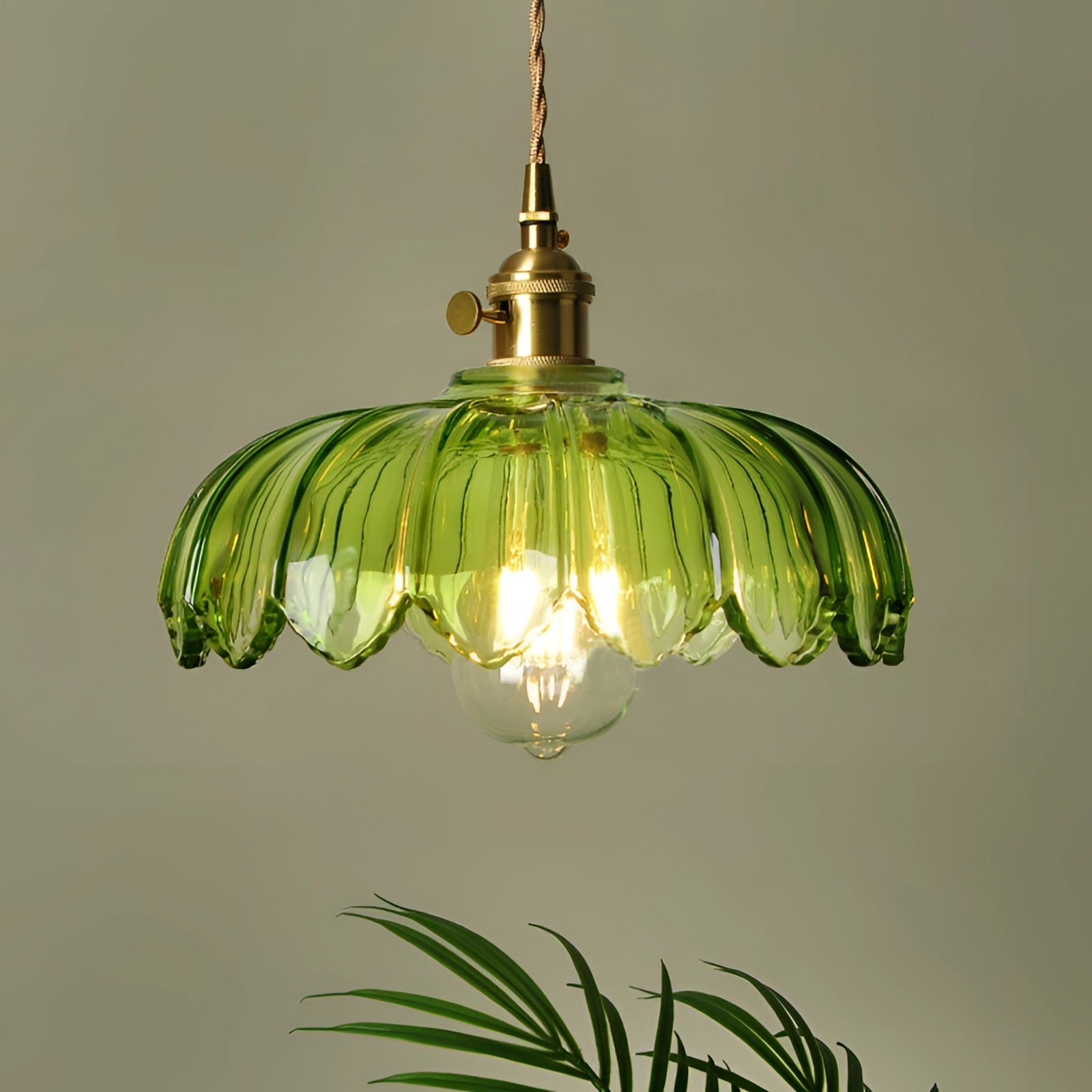 Amber Glass Pendant Light with Vintage Flower Design and Antique Brass Finish, hanging from ceiling, featuring ornate metalwork and warm light bulb.
