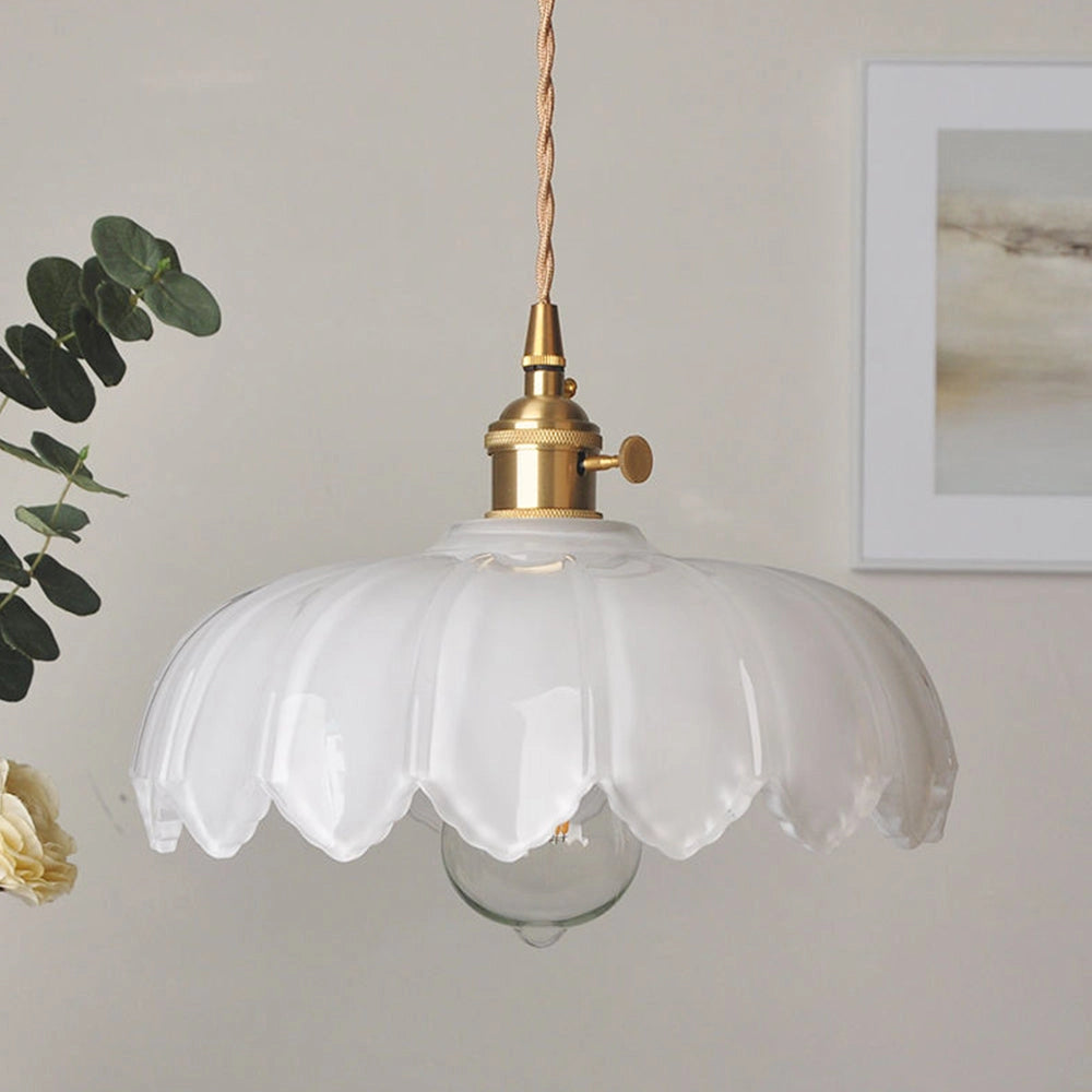 Vintage-inspired amber glass pendant light with antique brass finish, featuring a flower design and a visible light bulb, hanging from the ceiling as a stylish and artistic ceiling fixture.