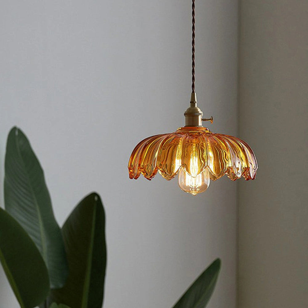 Vintage flower-themed amber glass pendant light with antique brass finish, featuring intricate twig and plant designs, hanging against a neutral background.