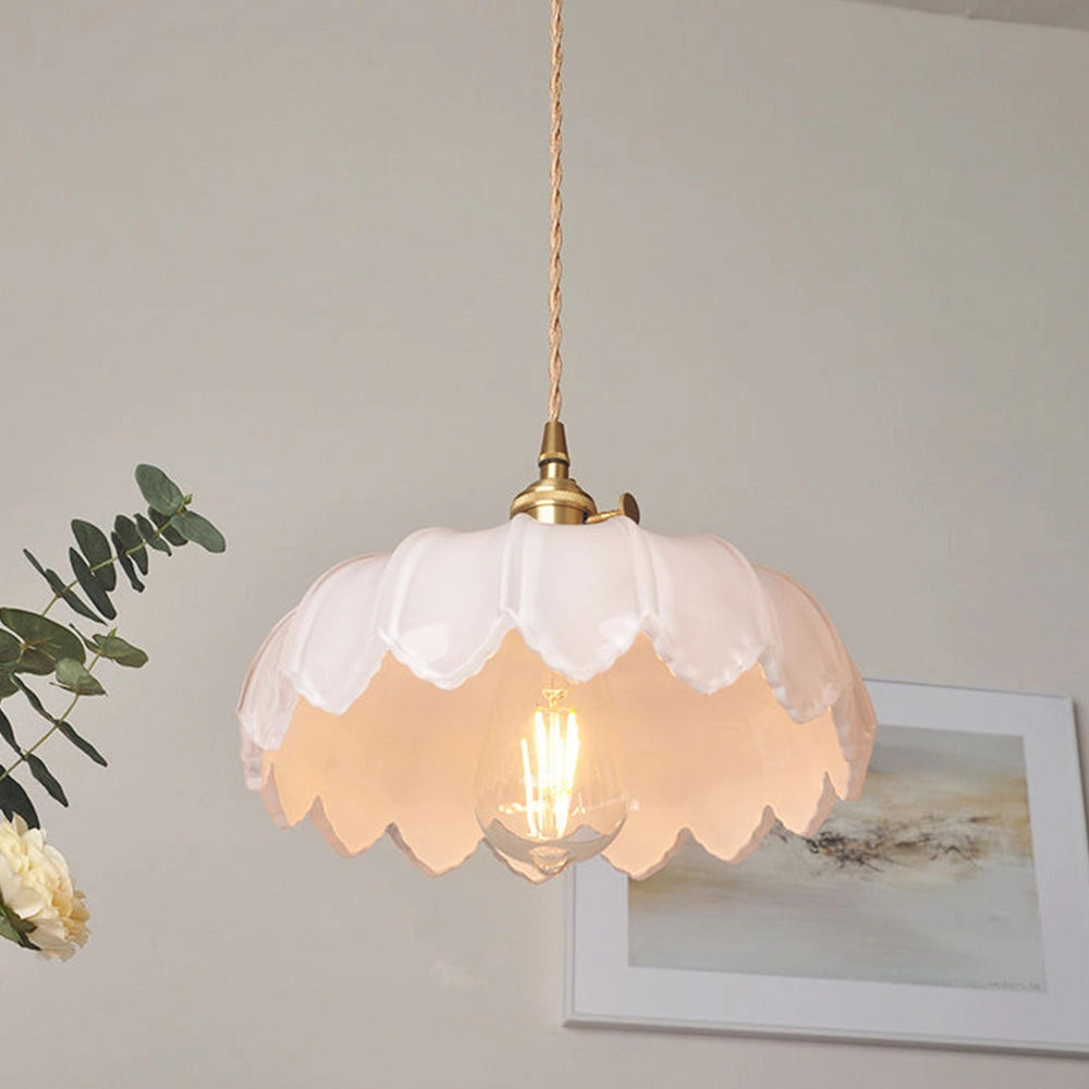 Amber Glass Pendant Light with Vintage Flower Design and Antique Brass Finish, hanging from the ceiling, featuring a decorative light bulb.