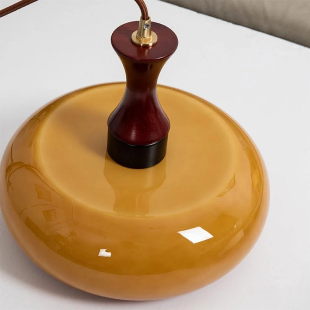 Amber glass retro pendant light with a mid-century modern design, featuring a glossy finish and a circular shape, stylishly illuminating any space.