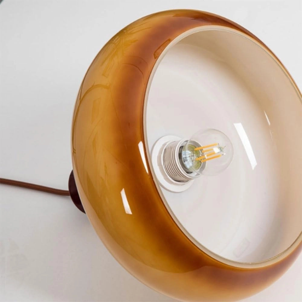 Amber glass retro pendant light with a mid-century modern design, featuring a circular shape and suspended by a wooden fixture.