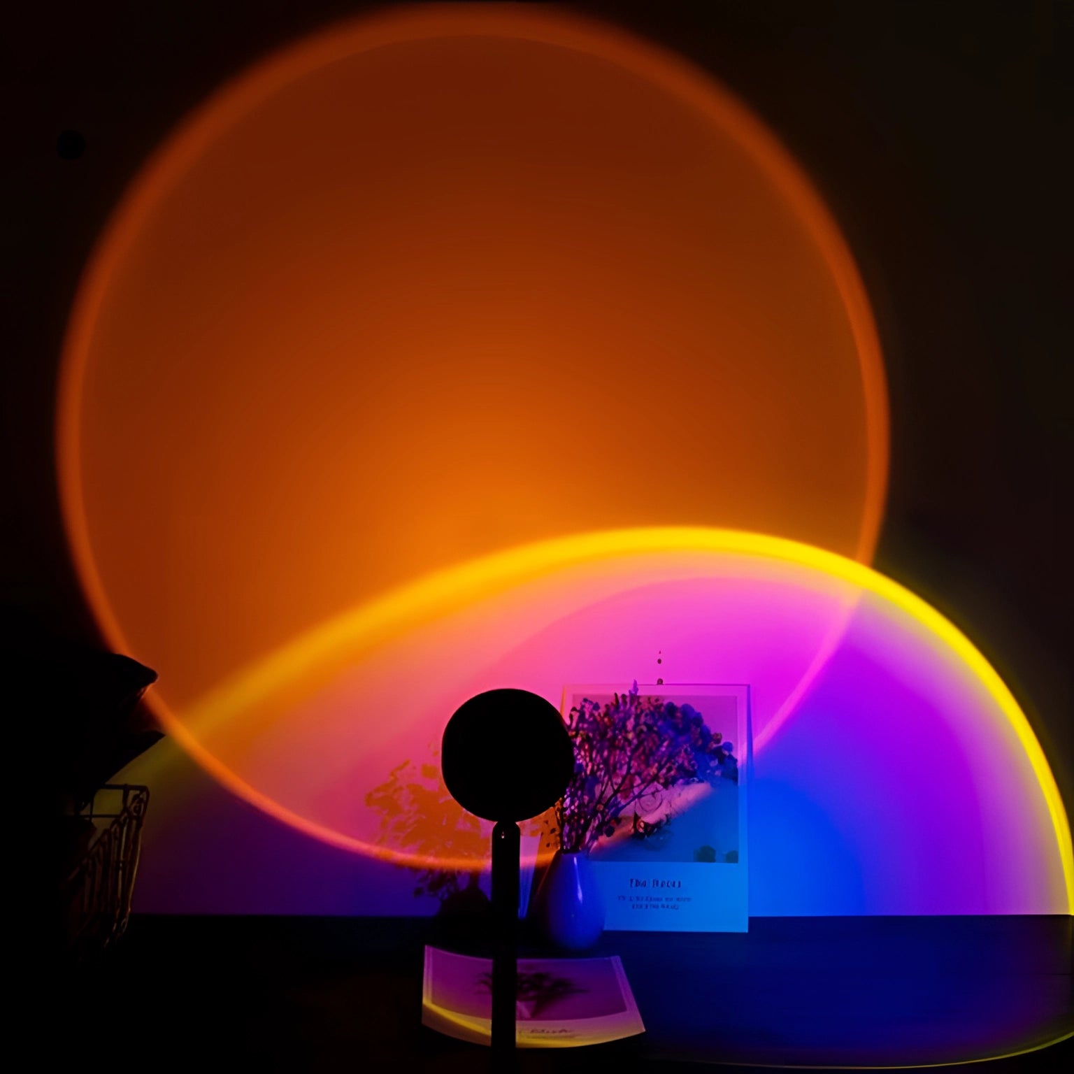 Ambient sunset light projector casting a warm orange glow with circular visual effects, creating an artistic atmosphere reminiscent of a sunset horizon, ideal for mood lighting in home decor.