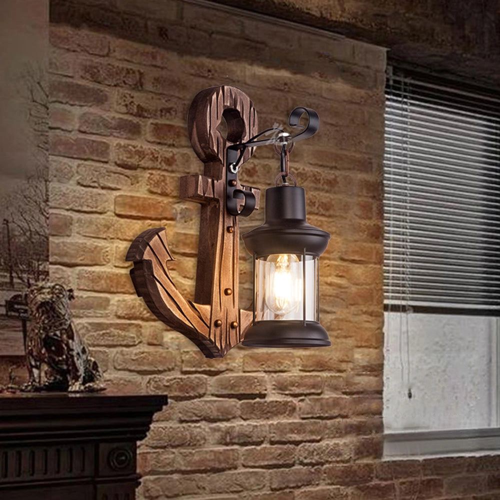Anchor-shaped nautical wall sconce in brown wood finish mounted on a brick wall, showcasing its rustic coastal design and interior decor appeal.