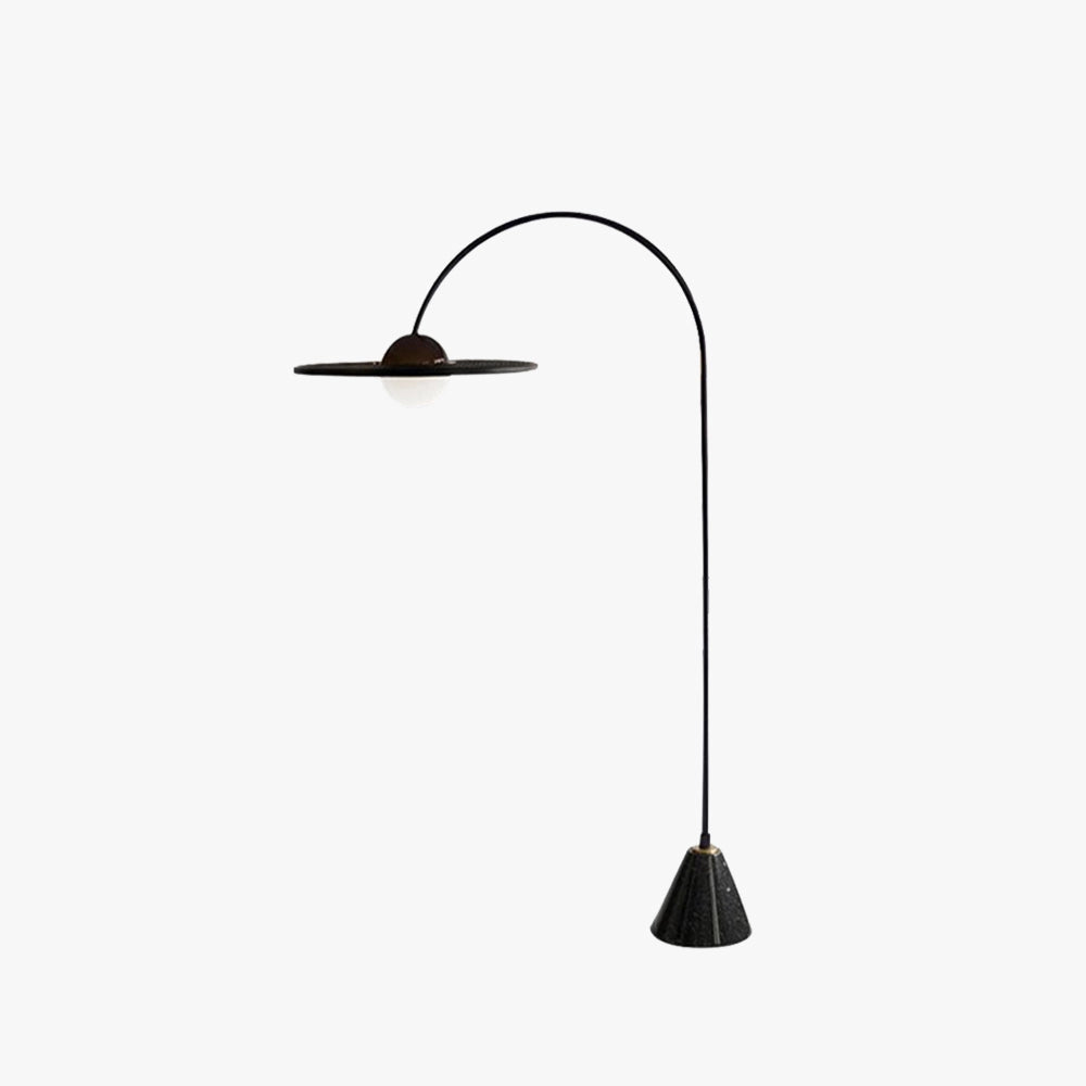 Arched Minimalist Floor Lamp featuring a modern black sculptural design with a sleek handle and circular light fixture, styled in a contemporary setting.