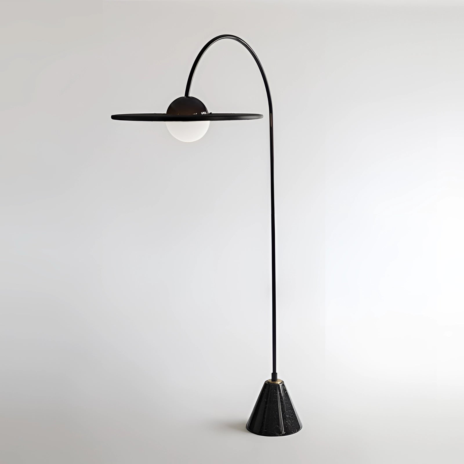 Arched minimalist floor lamp in modern black with a sculptural design, featuring a sleek metal construction and a balanced arch structure that adds a contemporary touch to interior decor.