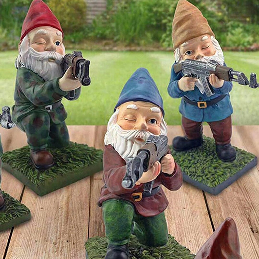 Armed Warrior Garden Gnome Statue featuring a garden gnome in military attire holding an AK-47, set amidst greenery and grass, designed as a guerrilla-themed lawn ornament.