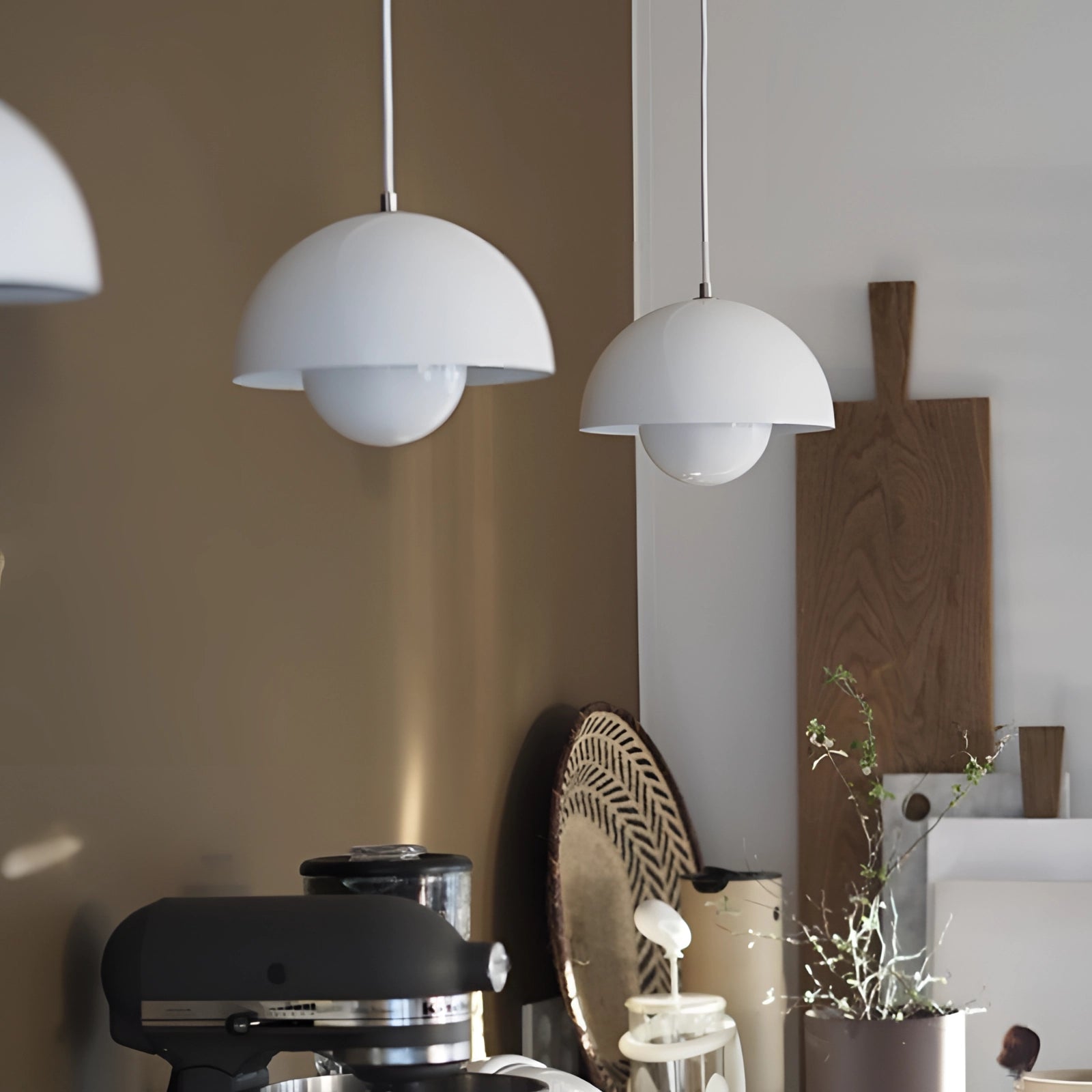 Modern retro pendant lights in yellow, white, and orange hanging above a wooden table, enhancing the interior design with a cozy and stylish ambiance.