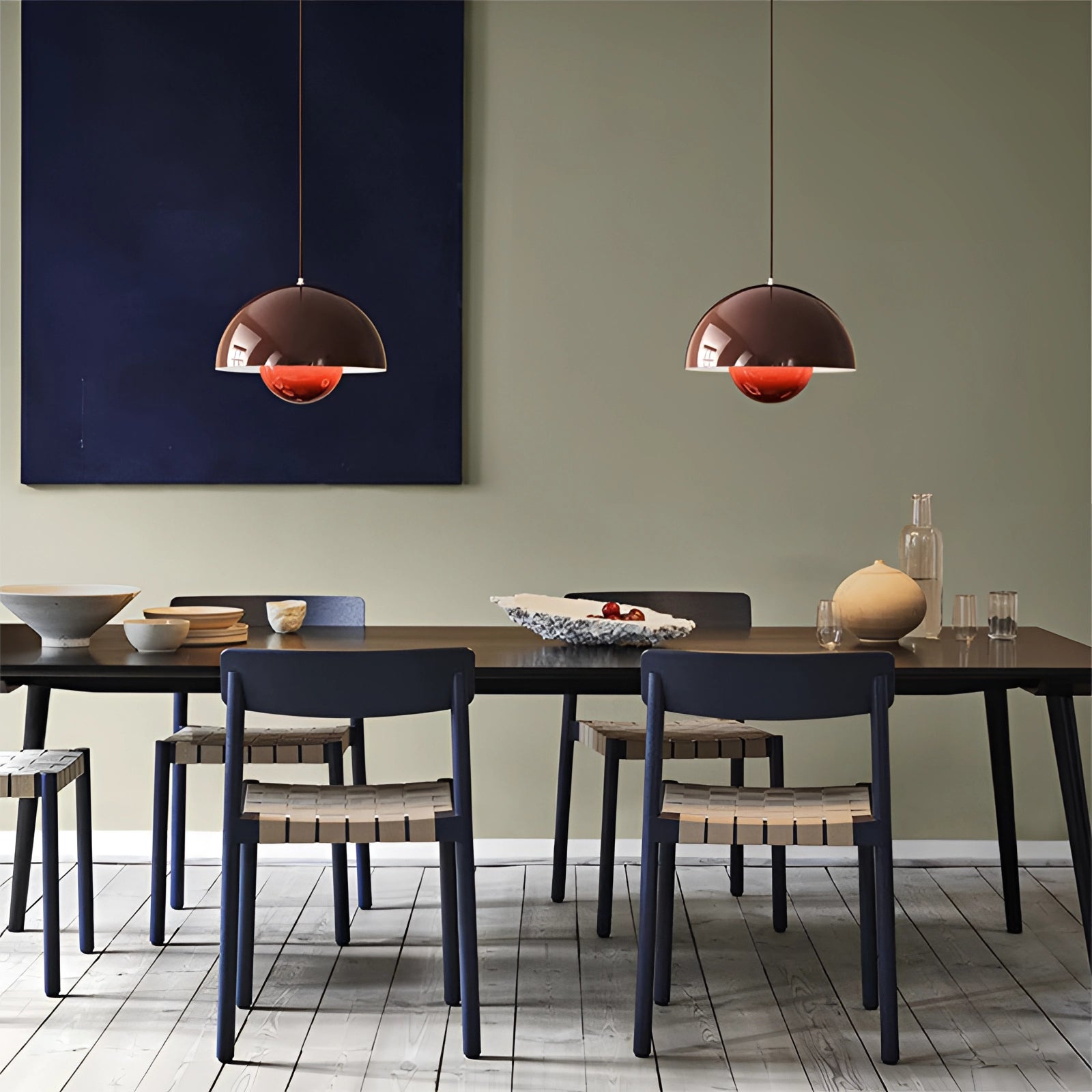 Modern retro pendant lights in yellow, white, and orange hanging above a wooden table in a stylish interior design setting.
