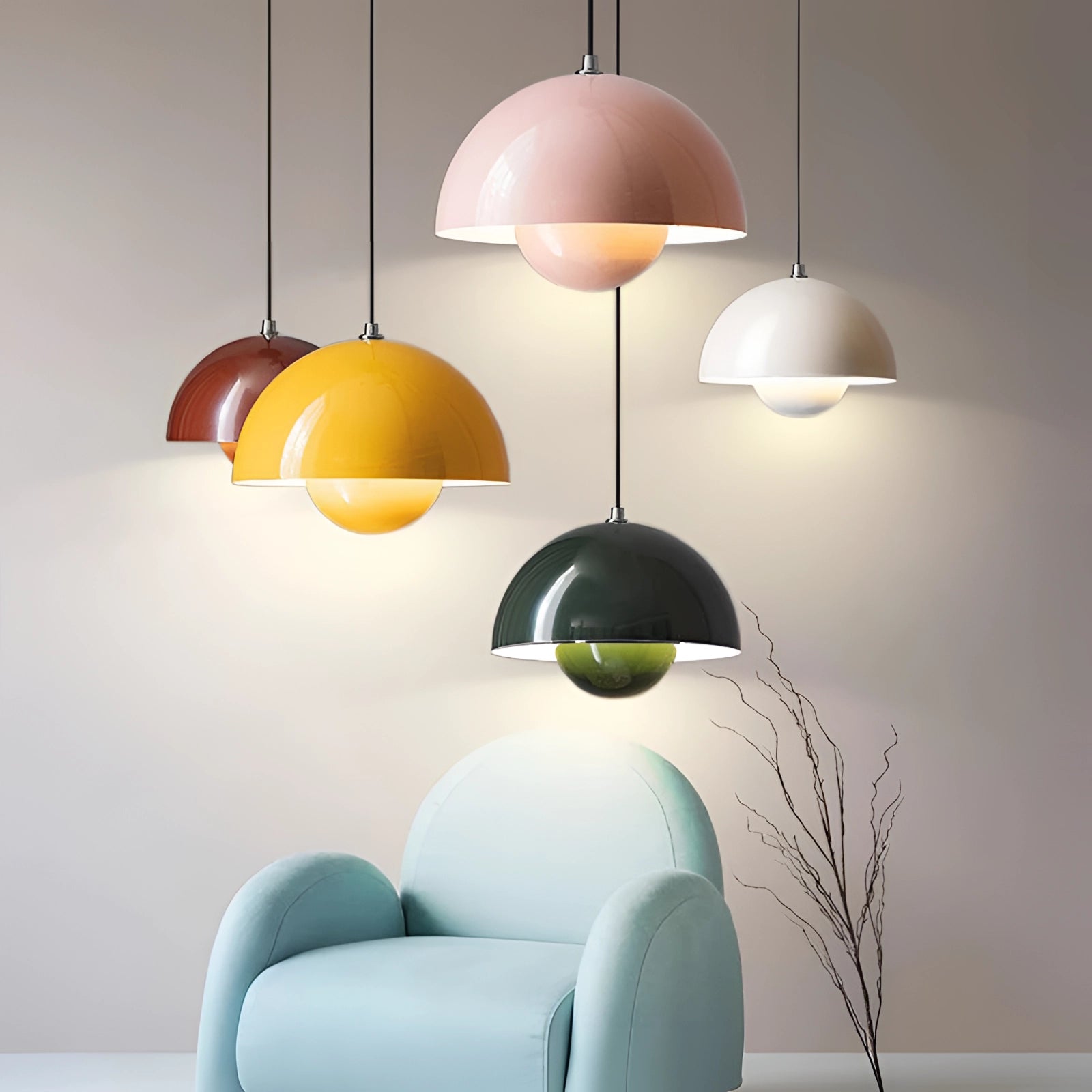 Modern retro pendant lights in yellow, white, and orange, hanging from the ceiling, illuminating a stylishly designed interior space with wall art and shelving.