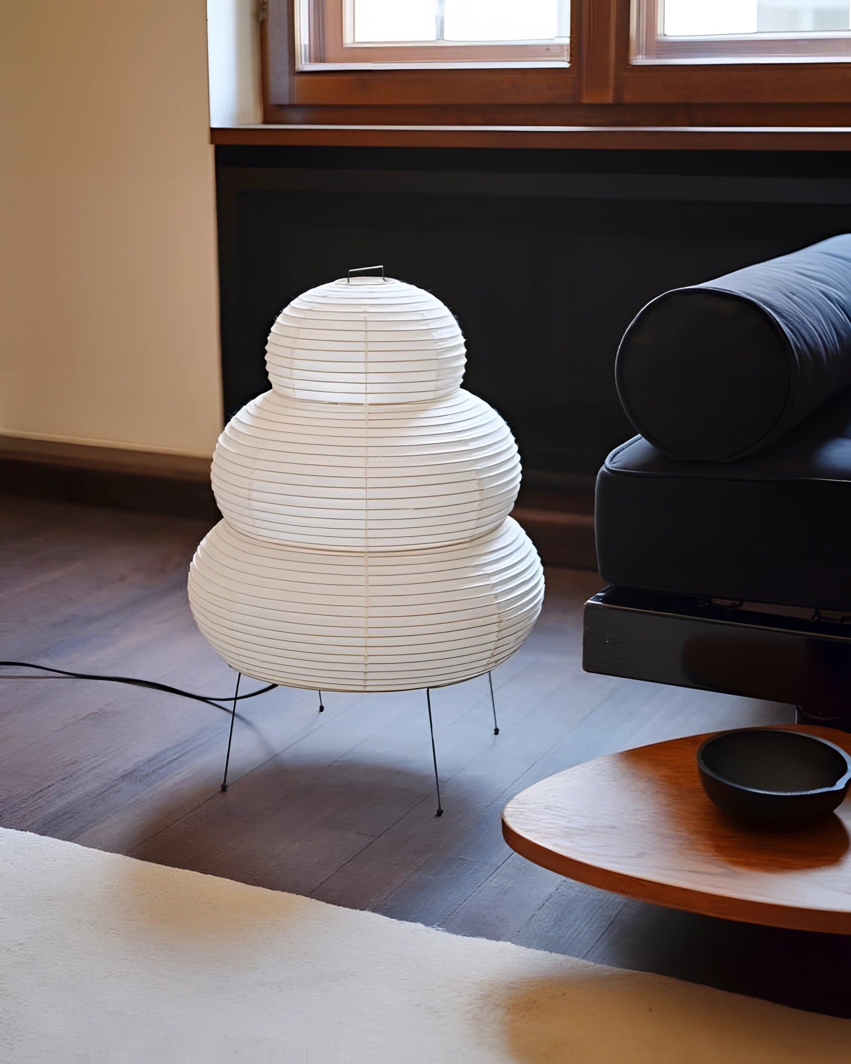 Unique Beehive Sculptural Tripod Floor Lamp placed in an elegantly designed interior space with wooden elements and a window in the background.