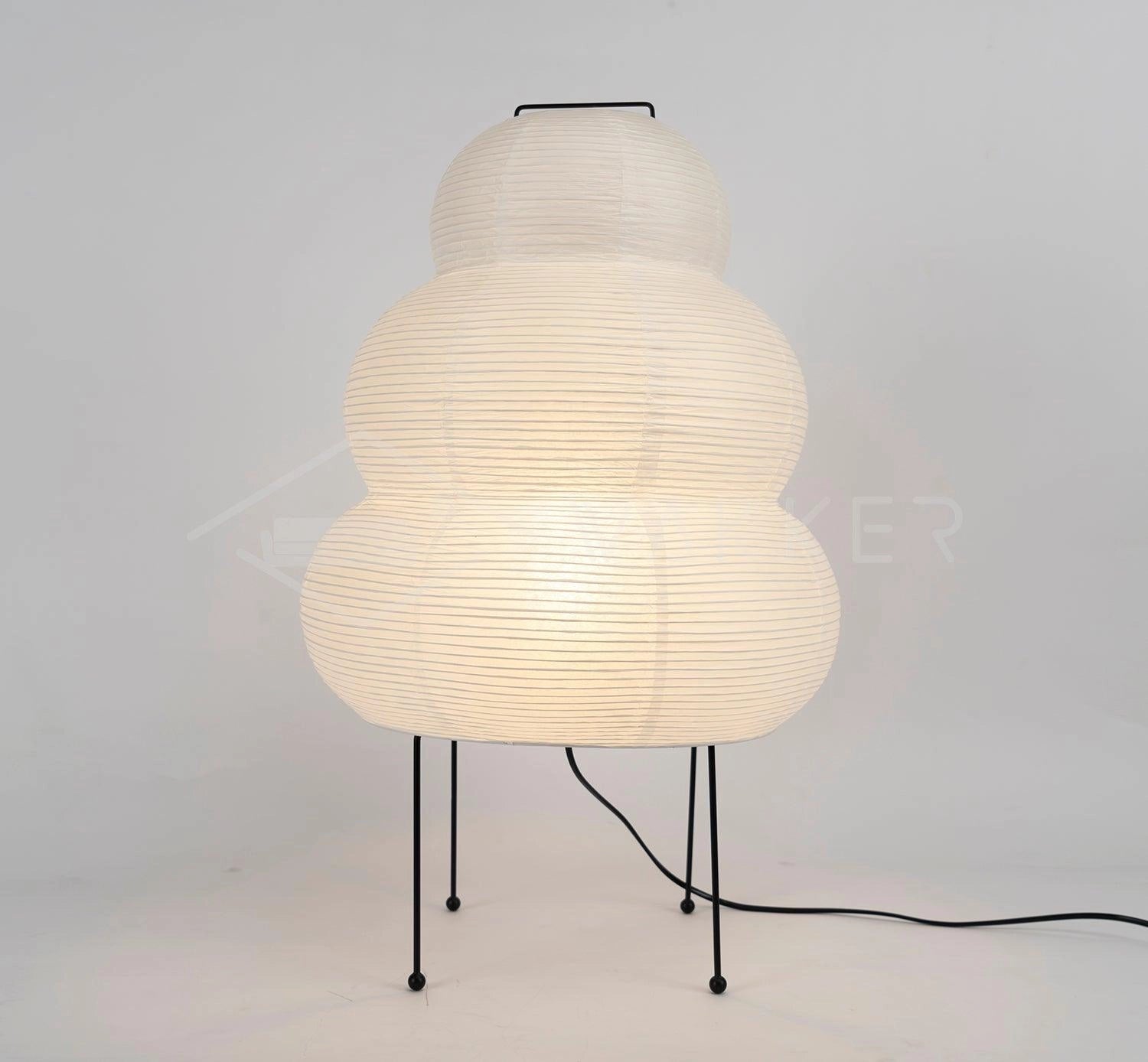 Beehive Sculptural Tripod Floor Lamp with unique design, featuring a metal frame and wooden tripod legs, positioned next to a table in a modern interior setting.