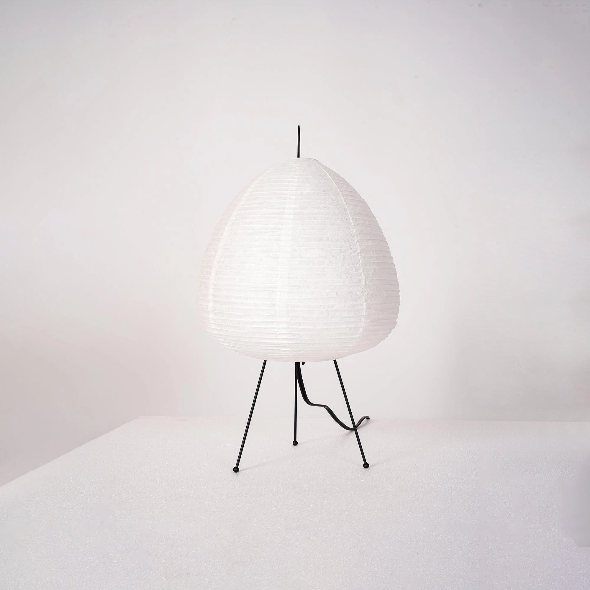 A sculptural tripod floor lamp with a beehive design, featuring a circular lampshade and unique statement lighting elements.