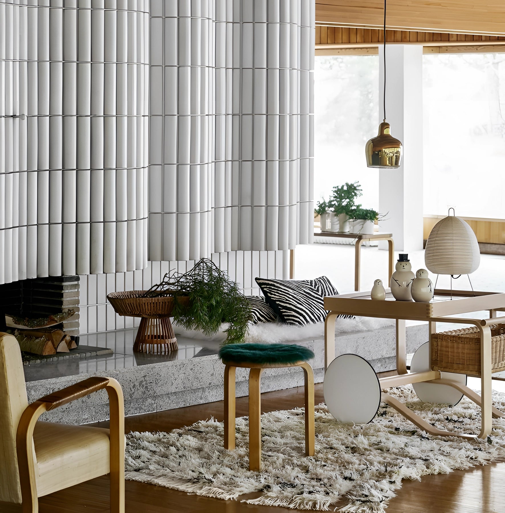 A sculptural tripod floor lamp with a beehive design, placed in a modern living room decorated with wooden furniture and indoor plants.