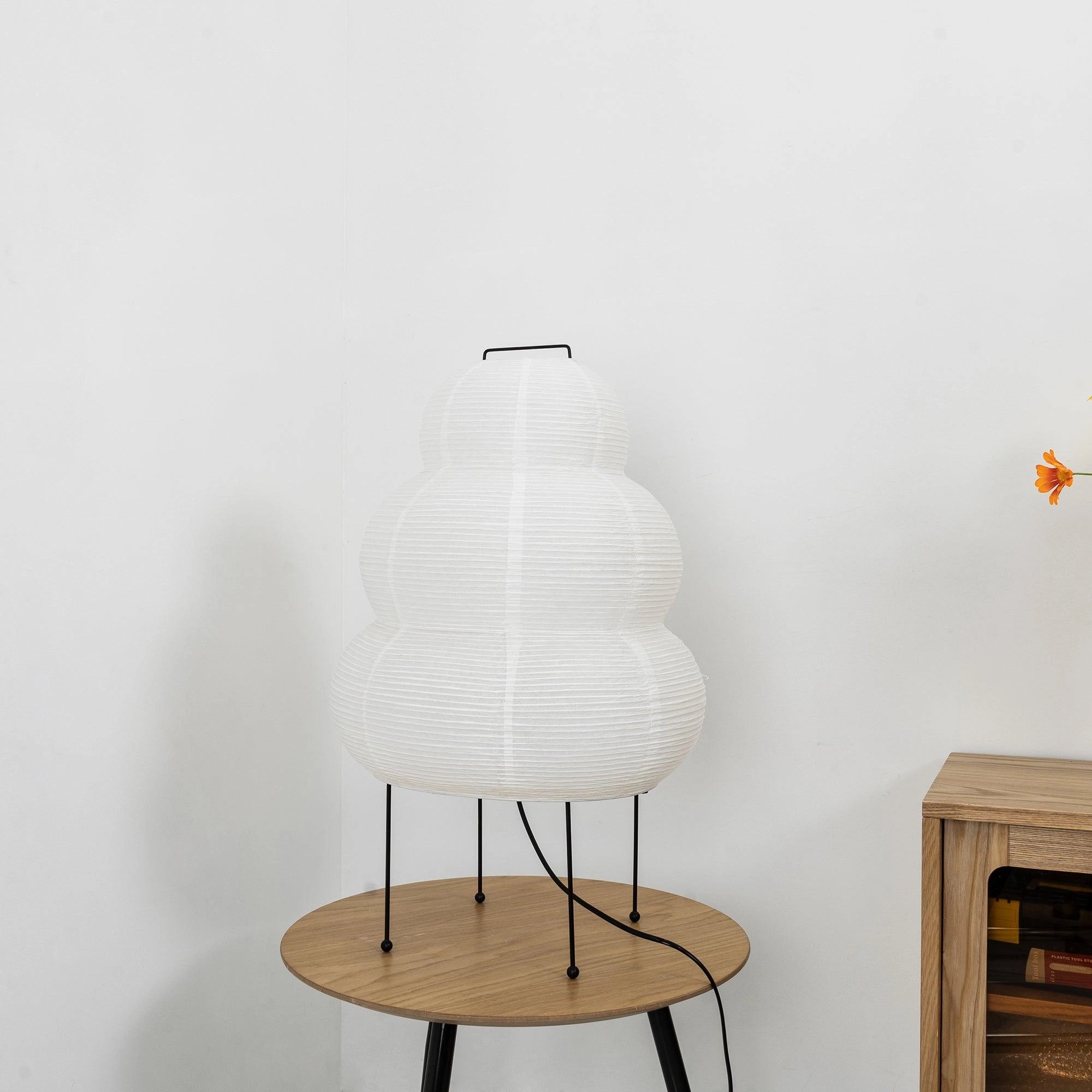 Beehive Sculptural Tripod Floor Lamp with unique design, featuring a wooden tripod base and a grey lampshade, placed in a stylish interior setting.