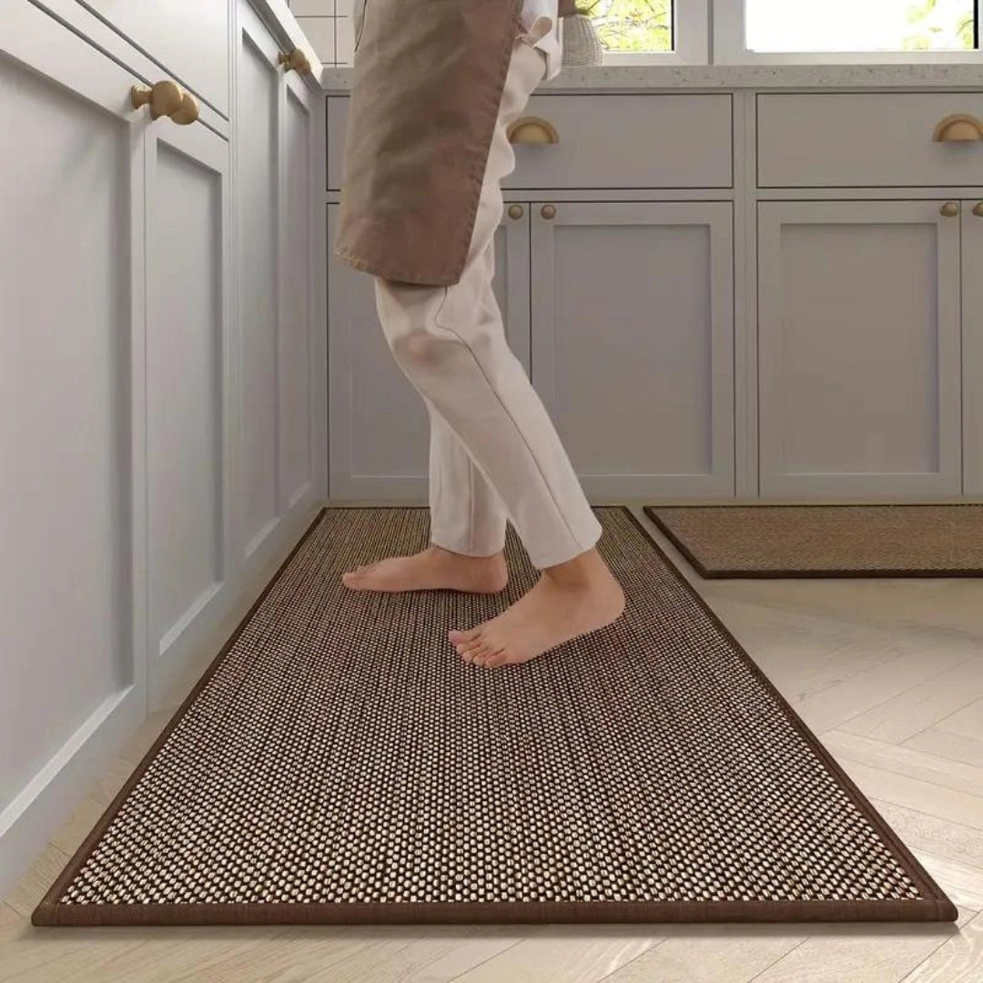 Beige non-slip anti-fatigue kitchen runner mat placed on a hardwood floor, providing cushioning support in front of a modern kitchen setup.