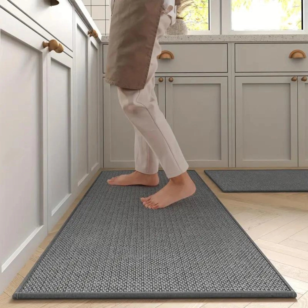 Dark grey non-slip anti-fatigue kitchen runner mat placed on a hardwood floor.
