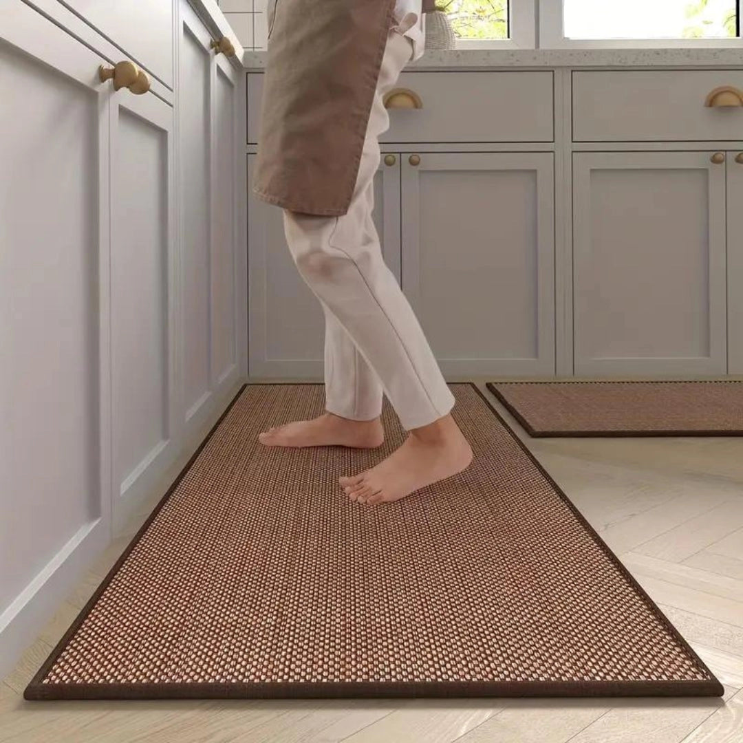 A beige non-slip anti-fatigue kitchen runner mat placed on a wooden floor, designed for comfort and support.