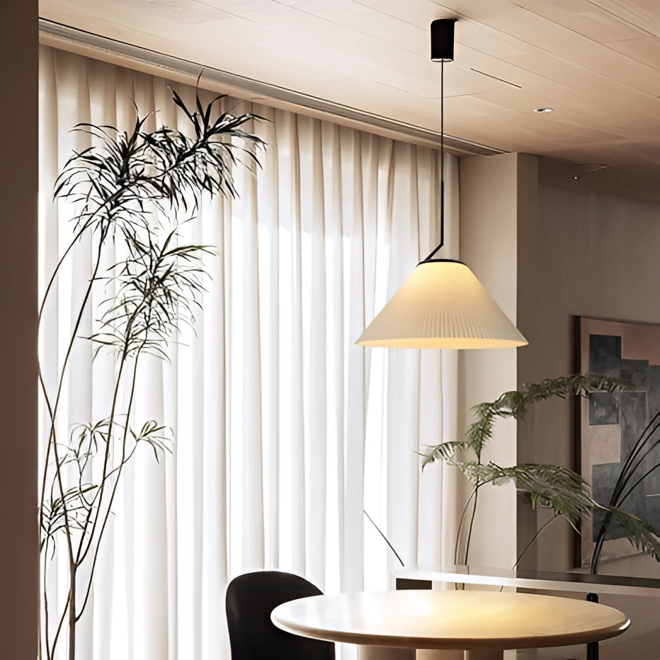 Beige Scandinavian cone pendant light hanging over a wooden dining table with plants, enhancing a minimalist modern interior design.