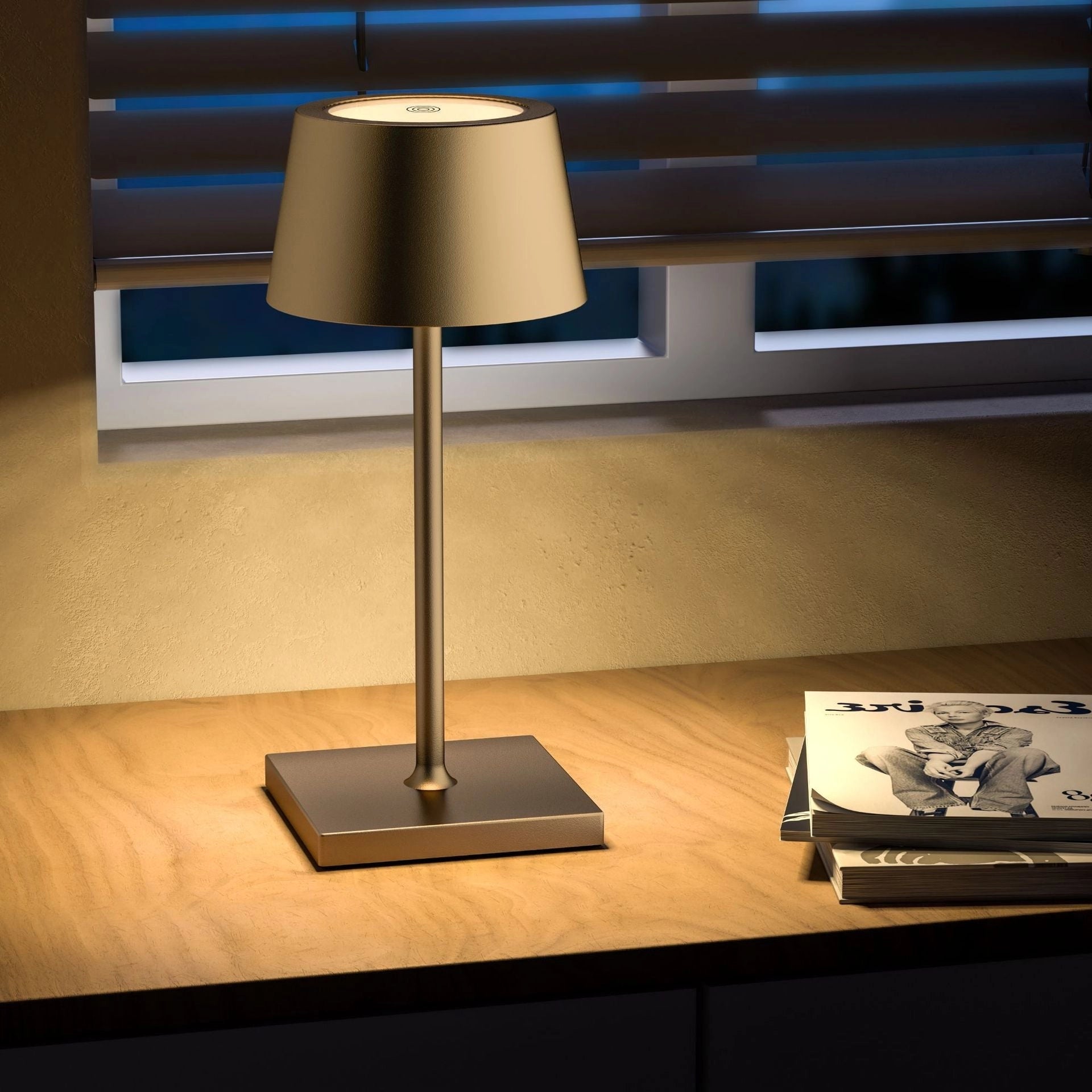 Black LED desk lamp with a sleek design featuring a touch sensor for adjustable brightness, positioned on a wooden surface next to audio equipment and shelving.