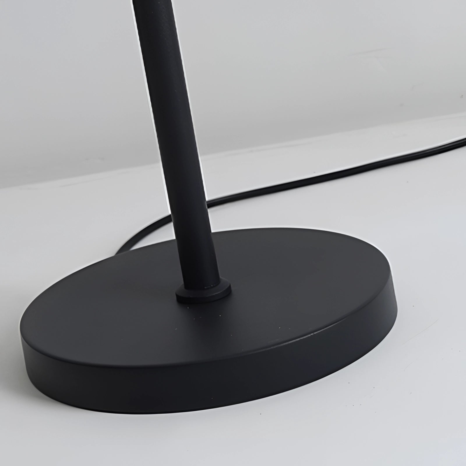 Sleek black minimalist coat stand made of metal with a modern freestanding design.