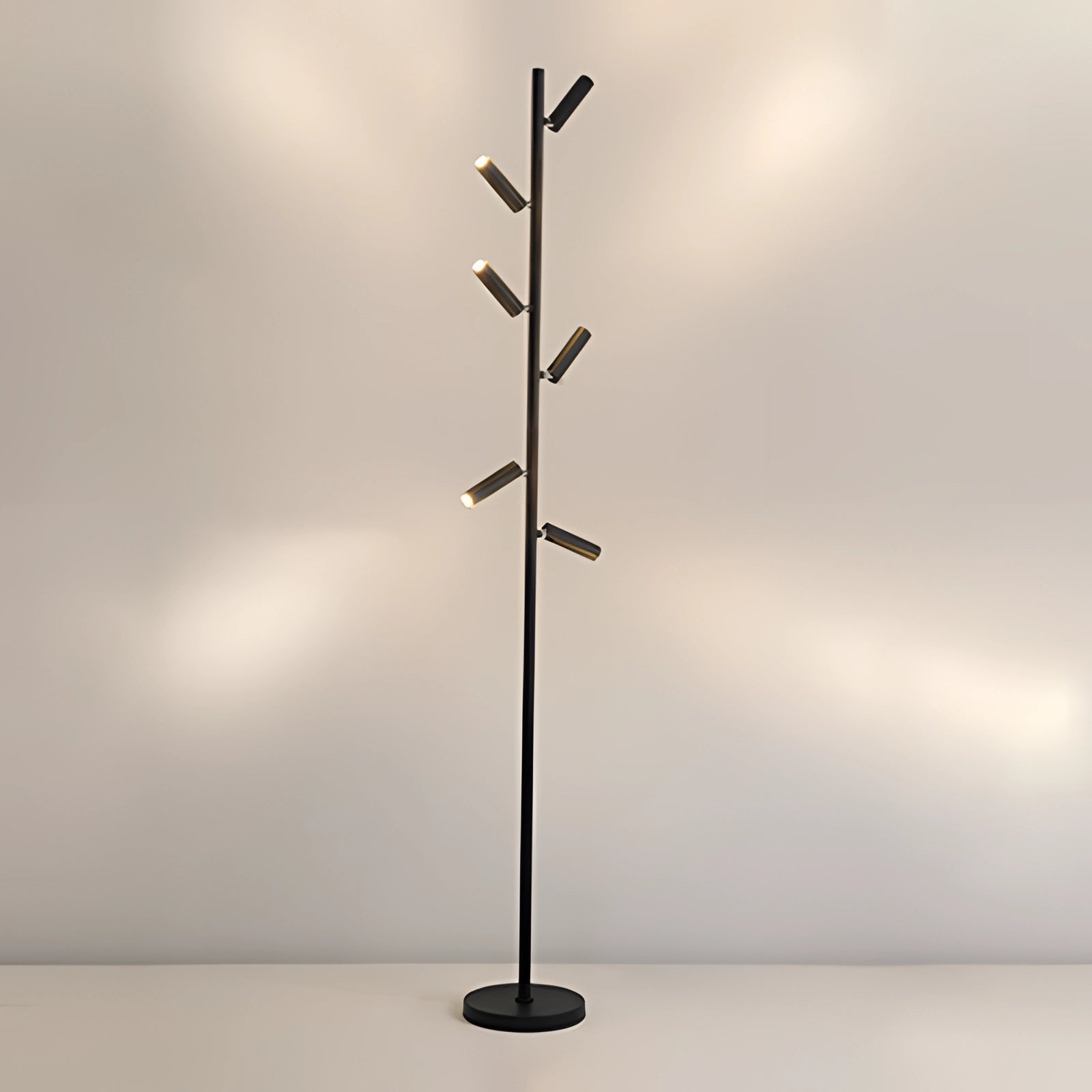 Black minimalist coat stand with six sleek arms, displayed in a warm light setting, showcasing its modern and freestanding design.