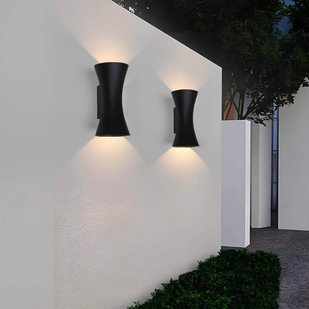 Black Outdoor LED Wall Sconce illuminating a wooden wall with an up and down light, showcasing its sleek, rectangular design and weather-resistant material.