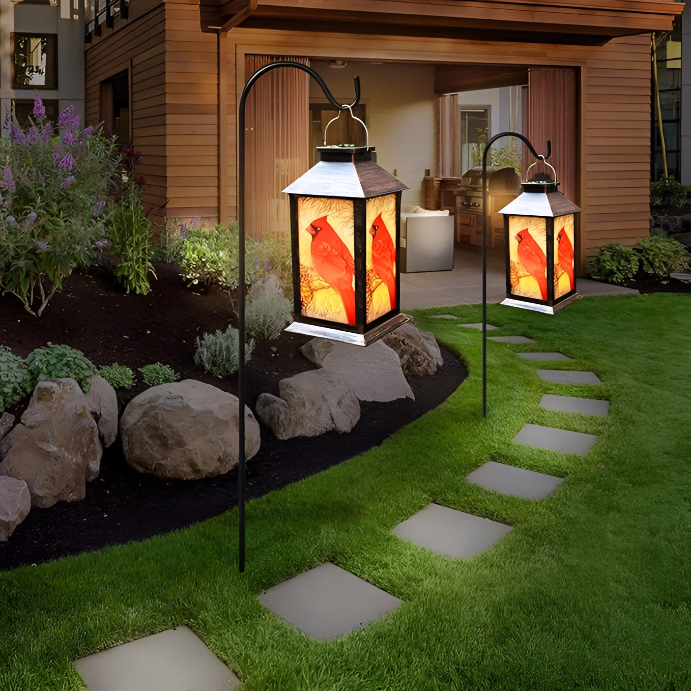 Rustic outdoor hanging light lantern featuring a cardinal bird design, surrounded by plants and greenery in a residential garden area.