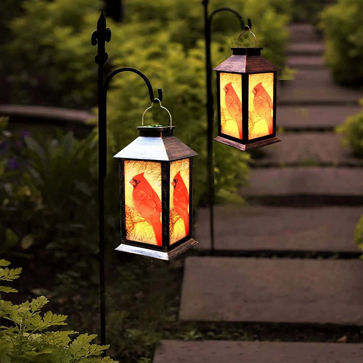 Rustic Cardinal Bird Lantern, amber light hanging among plants and trees, ideal for outdoor wildlife-themed decor.