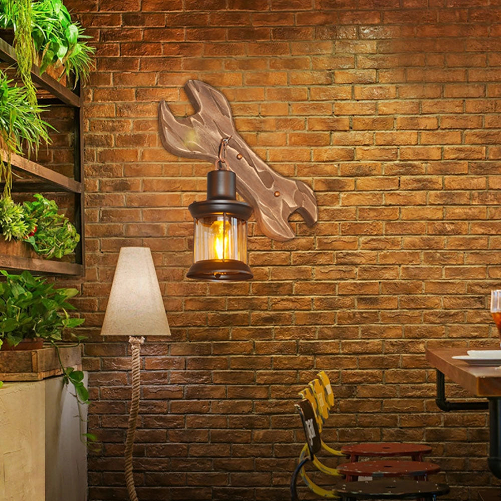 Coastal Whale Wall Sconce featuring a rustic nautical ocean design, mounted on a wooden brick wall, emitting a warm amber light.